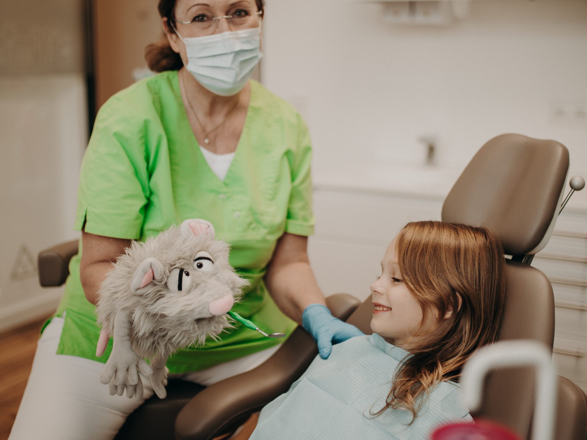 Kind bekommt vom Zahnarzt mit einer Handpuppe etwas erklärt in der Zahnarztpraxis Schnutenwerk in Kempen